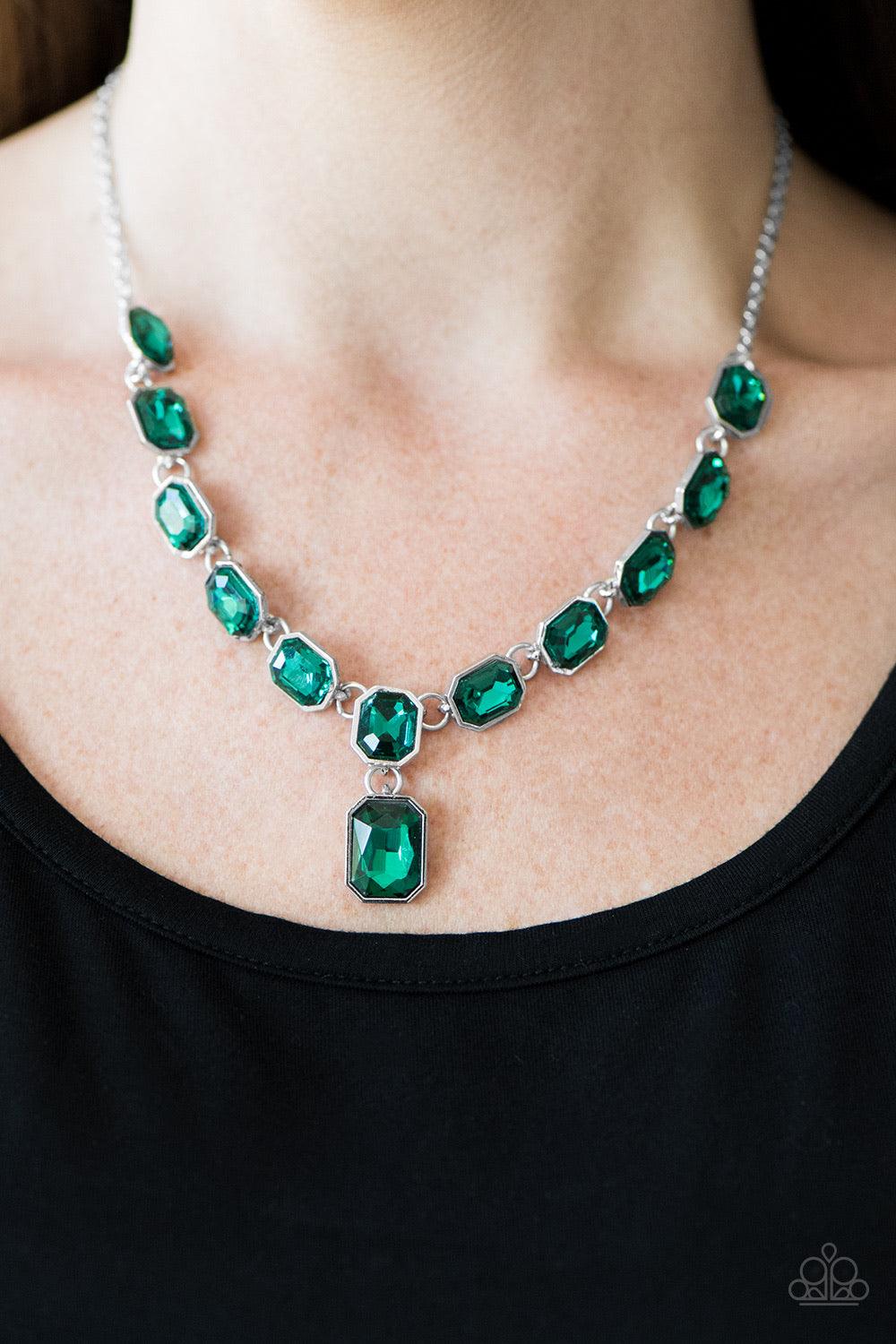 Paparazzi Accessories The Right To Remain Sparkly - Green Featuring regal emerald style cuts, glittery green gems link below the collar in an undeniably sparkly fashion. A slightly larger gem swings from the center, creating an eye-catching pendant. Featu