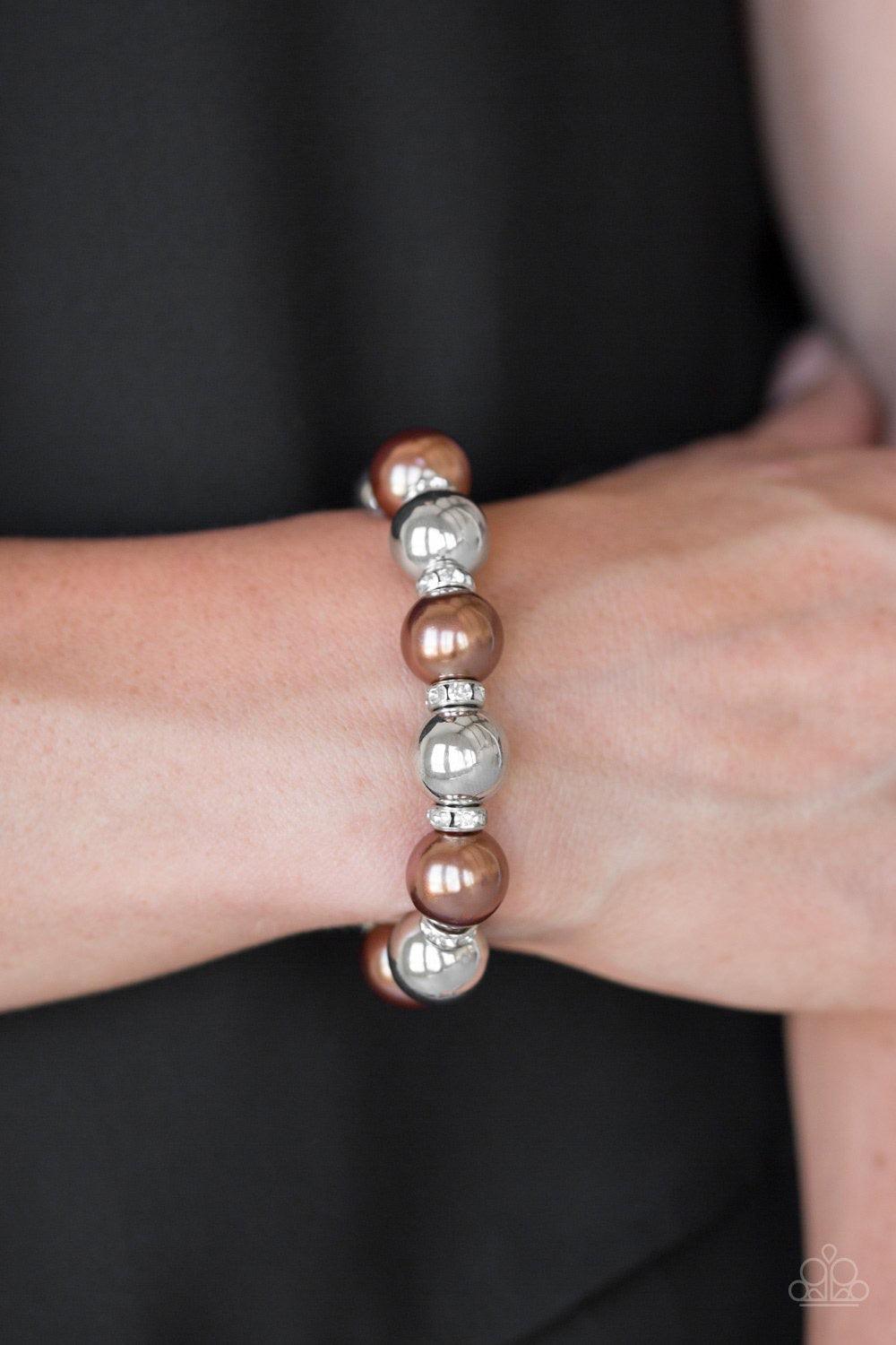 Paparazzi Accessories So Not Sorry - Brown A collection of white rhinestone encrusted rings, brown pearls, and classic silver beads are threaded along a stretchy band around the wrist for a glamorous look. Jewelry