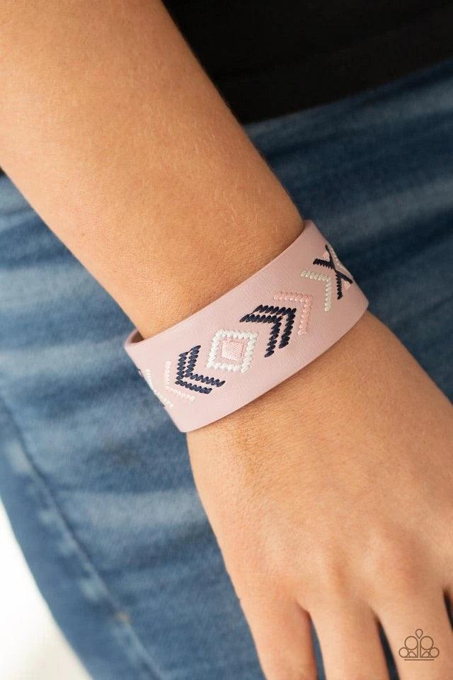 Paparazzi Accessories Cliff Glyphs - Pink Pink, blue, and white thread is stitched across the front of a pink leather band, creating a colorful tribal inspired pattern. Features an adjustable snap closure. Jewelry