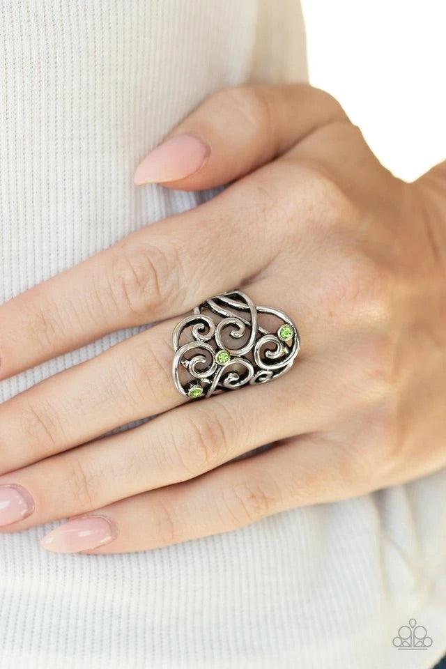 Paparazzi Accessories FRILL Out! - Green Dainty green rhinestones are sprinkled across an airy backdrop of swirling silver filigree, creating a whimsical centerpiece. Features a stretchy band for a flexible fit. Jewelry