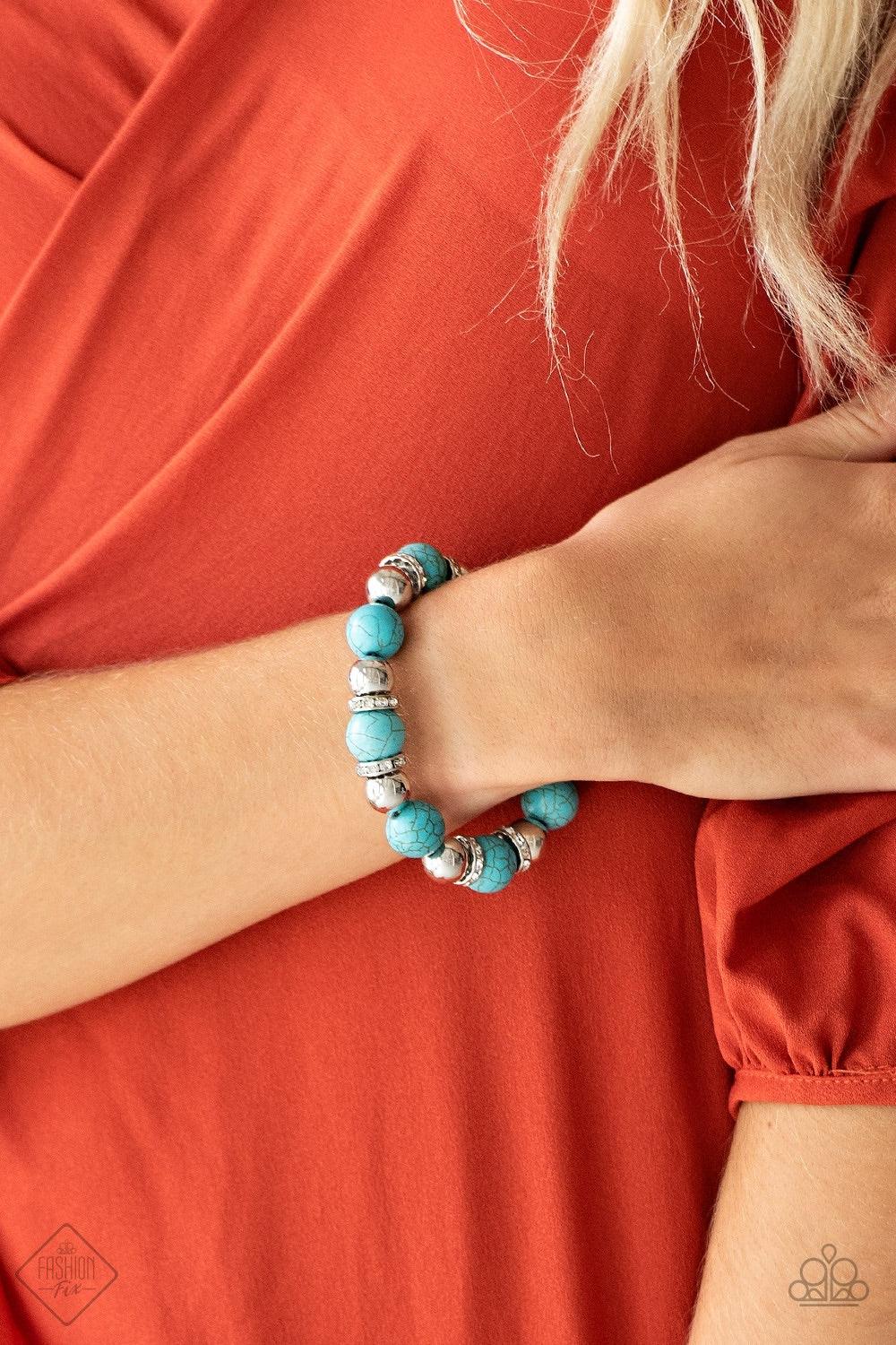 Paparazzi Accessories Ruling Class Radiance - Blue Faux turquoise stones, shiny silver beads, and white rhinestone encrusted rings are threaded along a stretchy band and wrapped around the wrist for an elegantly earthy finish. Jewelry