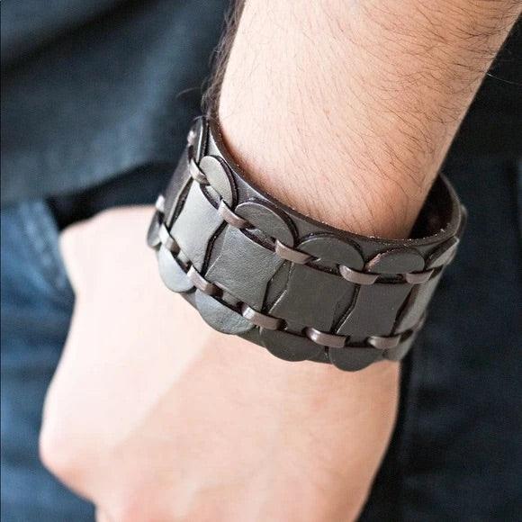 Paparazzi Accessories Traffic Control - Brown Brown leather cording laces through rounded leather pieces, securing the leather accents across the front of a thick leather band for an urban look. Features an adjustable snap closure. Sold as one individual