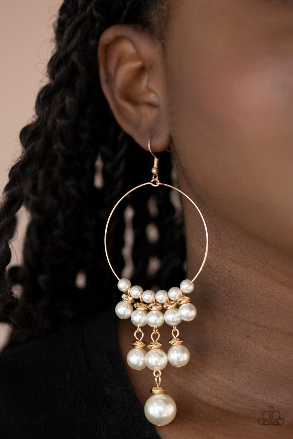Paparazzi Accessories Working The Room ~Gold Tiers of faceted gold beads and bubbly white pearls dangle from the bottom of a dainty gold wire hoop, creating an elegant fringe. Earring attaches to a standard fishhook fitting. Sold as one pair of earrings.