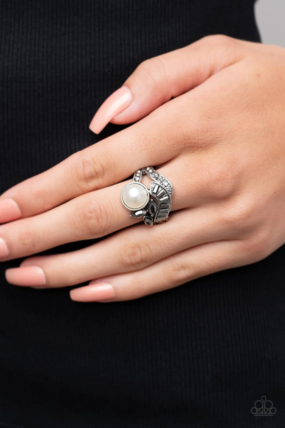 Paparazzi Accessories SELFIE-Made Millionaire - Silver Silver ribbons adorned in round and emerald cut hematite rhinestones delicately nestle around an oversized white pearl. Enhanced with a trio of marquise cut hematite rhinestones, the lavishly layered