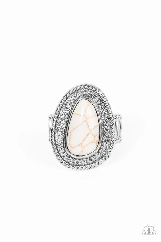Paparazzi Accessories Downtown Desertscape - White An asymmetrical white stone imperfectly adorns the center of a hammered silver frame bordered in spun silver detail, resulting in a radiant rustic centerpiece atop the finger. Features a stretchy band for