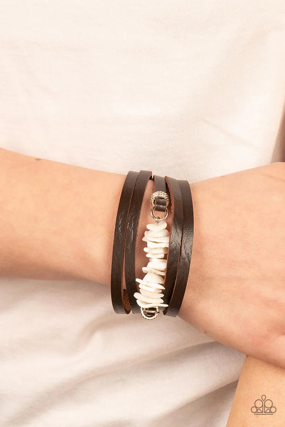 Paparazzi Accessories Tropical Trek - White A brown leather band is spliced into rugged layers around the wrist. Infused with textured silver rings, the centermost strand is infused with a stack of white shell-like accents for a tropical inspired finish.
