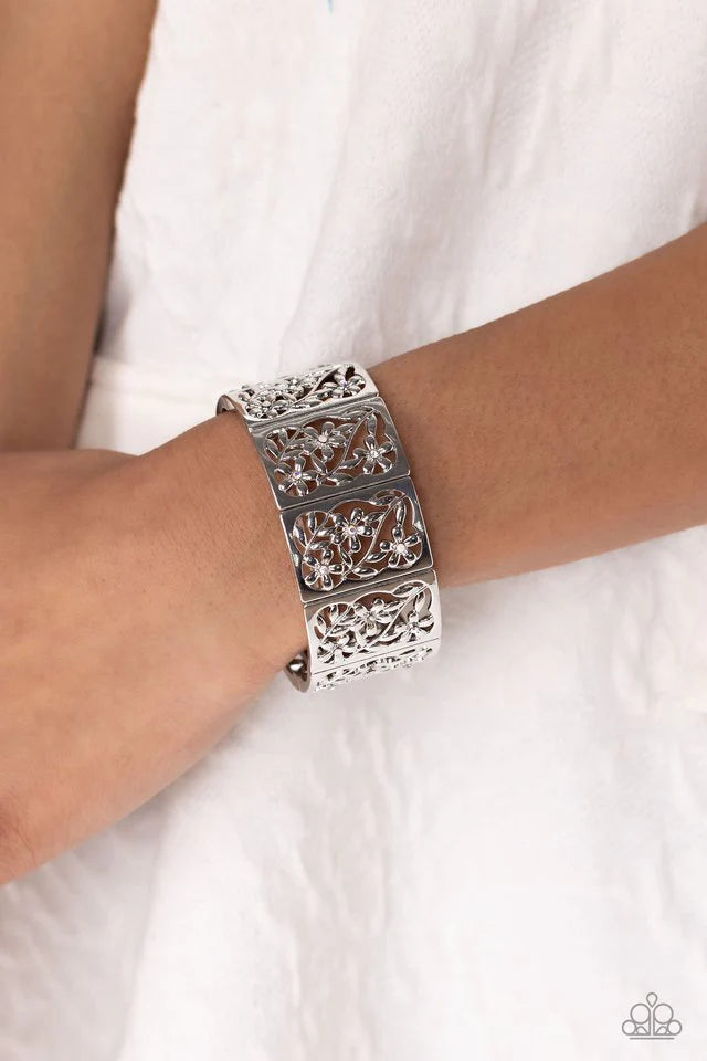 Paparazzi Accessories Garden Walls - White Sleek silver frames, filled with whimsical leafy floral filigree and opalescent, white, and iridescent rhinestones, stack around the wrist on an elastic stretchy band for a dainty handcrafted statement. Due to it