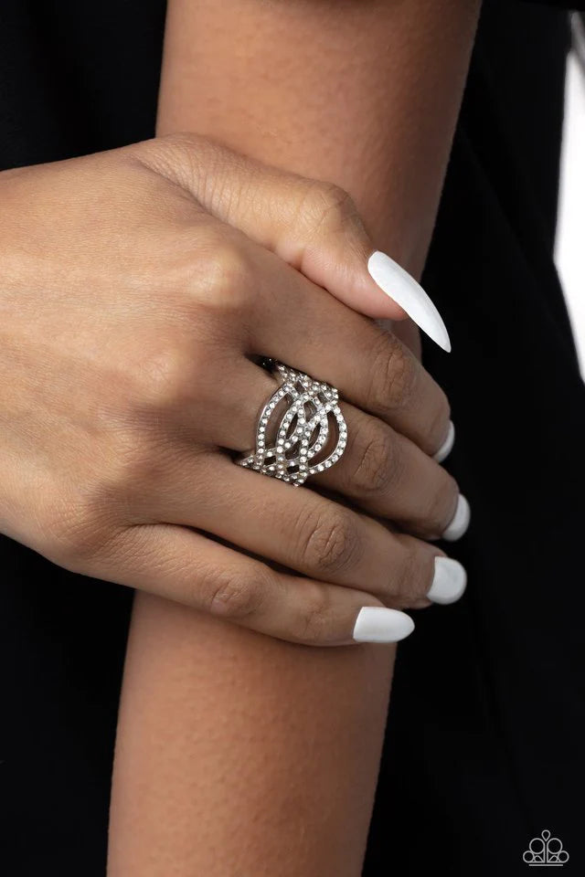 Paparazzi Accessories Interlocked Impression - White A silver frame, lined with white rhinestones, creates the illusion of endless sparkle as each silver band arcs and curls across the finger, allowing the skin to peek through the airy bands for a whimsic