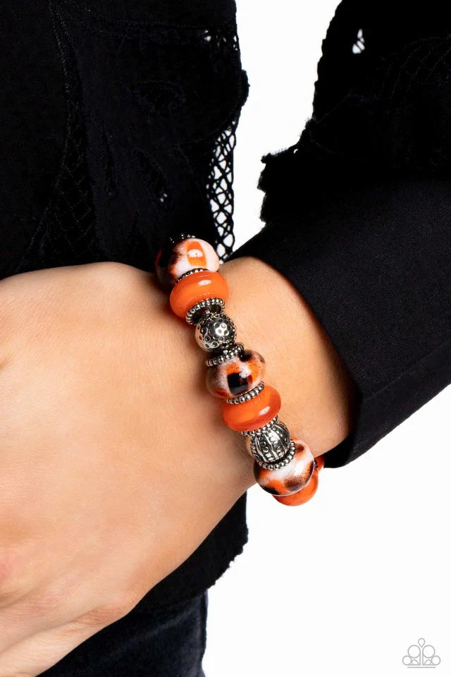 Paparazzi Accessories Warped Wayfarer - Orange An earthy collection of dotted silver beads, rounded milky orange beads, studded silver rings, orange-spotted ceramic-like beads and textured silver beads are threaded along an elastic stretchy band around th