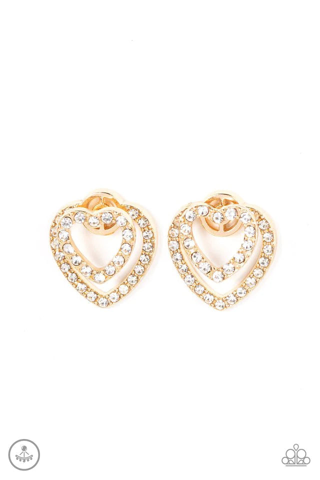 Paparazzi Accessories Ever Enamored - Gold A dainty gold heart dotted in glassy white rhinestones flirtatiously attaches to a double-sided post, while a slightly larger white rhinestone encrusted gold heart peeks out beneath the ear for a romantic finish.