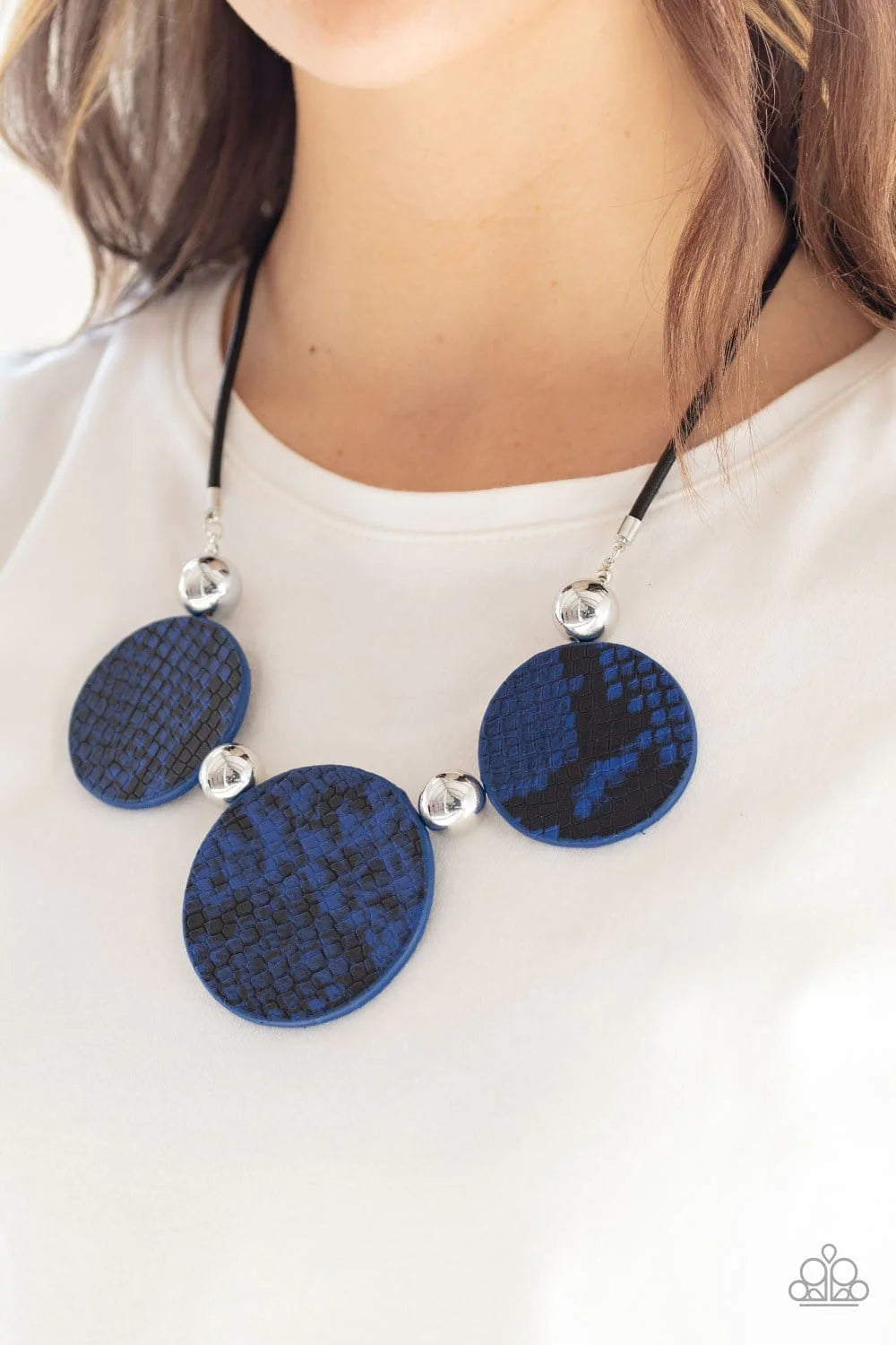 Paparazzi Accessories Viper Pit - Blue A wild collection of oversized silver beads and blue and black python patterned leather pieces are strung along an invisible wire below the collar for a statement-making finish. Features an adjustable clasp closure.