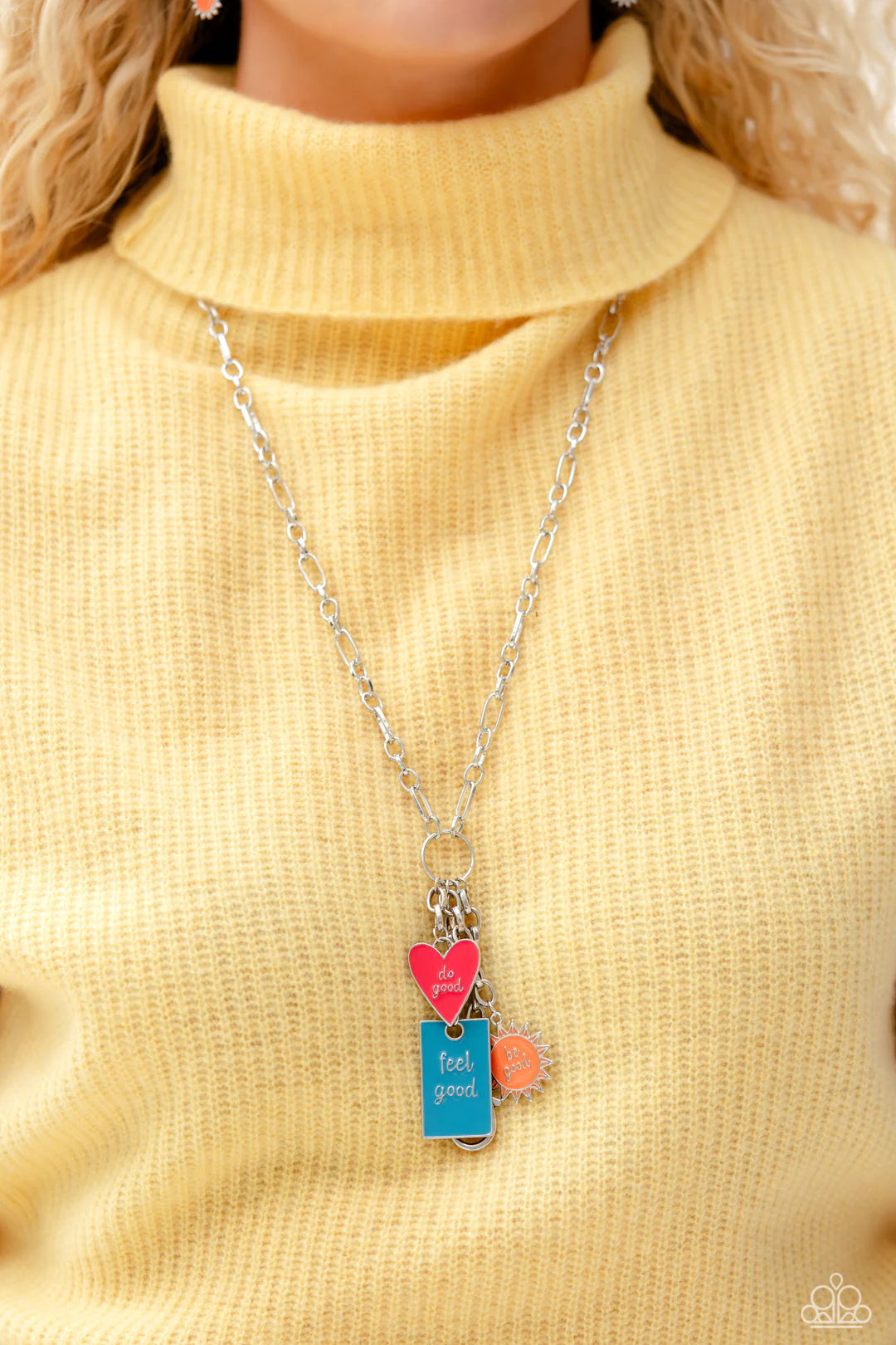 Paparazzi Accessories Embracing Good - Multi Featuring a glossy finish, a Pink Peacock heart, orange sun, and turquoise rectangle cascade from the bottom of a lengthened, trendy silver chain. Inscribed on each charm, the phrases "do good," "be good," and