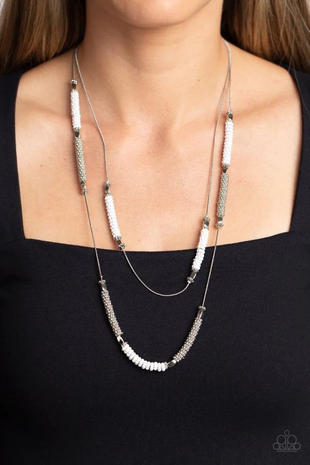 Paparazzi Accessories Caviar Chic - White Featuring a layered display, two elongated silver snake chains dance down the neckline. Sections of shiny silver flower beads, capped by high sheen silver accents, are interspersed with stacks of white and silver