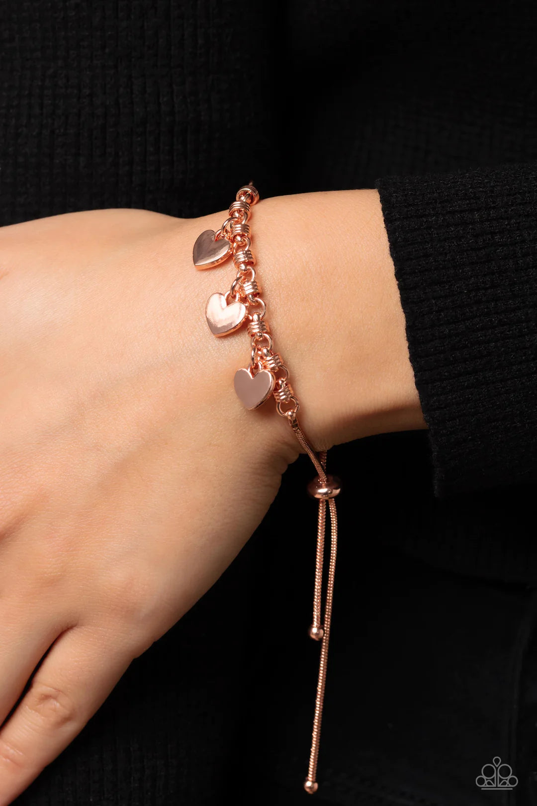 Paparazzi Accessories Romance Tale - Copper Dangling from a shiny copper snake chain, a trio of shiny copper hearts link across the wrist for a dash of swoon-worthy sheen. Infused along the heart chain, shiny copper spiral-like accents add additional text