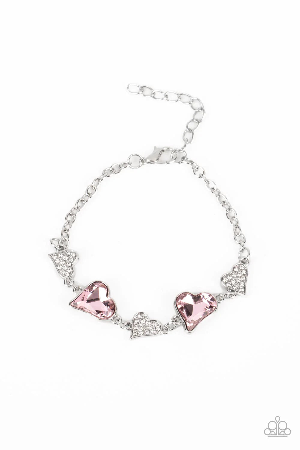 Paparazzi Accessories Cluelessly Crushing - Pink An asymmetrical collection of hearts coalesce around the wrist in this flirty centerpiece. Three of the silver hearts are encrusted with dainty white rhinestones, while the other two heart frames boast soft