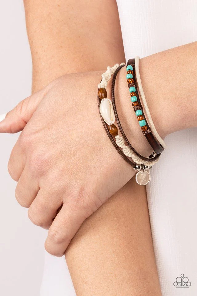 Paparazzi Accessories Tidal Dream - Blue An assortment of colorful seed beads, white shells, and earthy wooden accents adorns mismatched strands of leather and colorful cording around the wrist for a summery vibe. Features an adjustable sliding knot closu