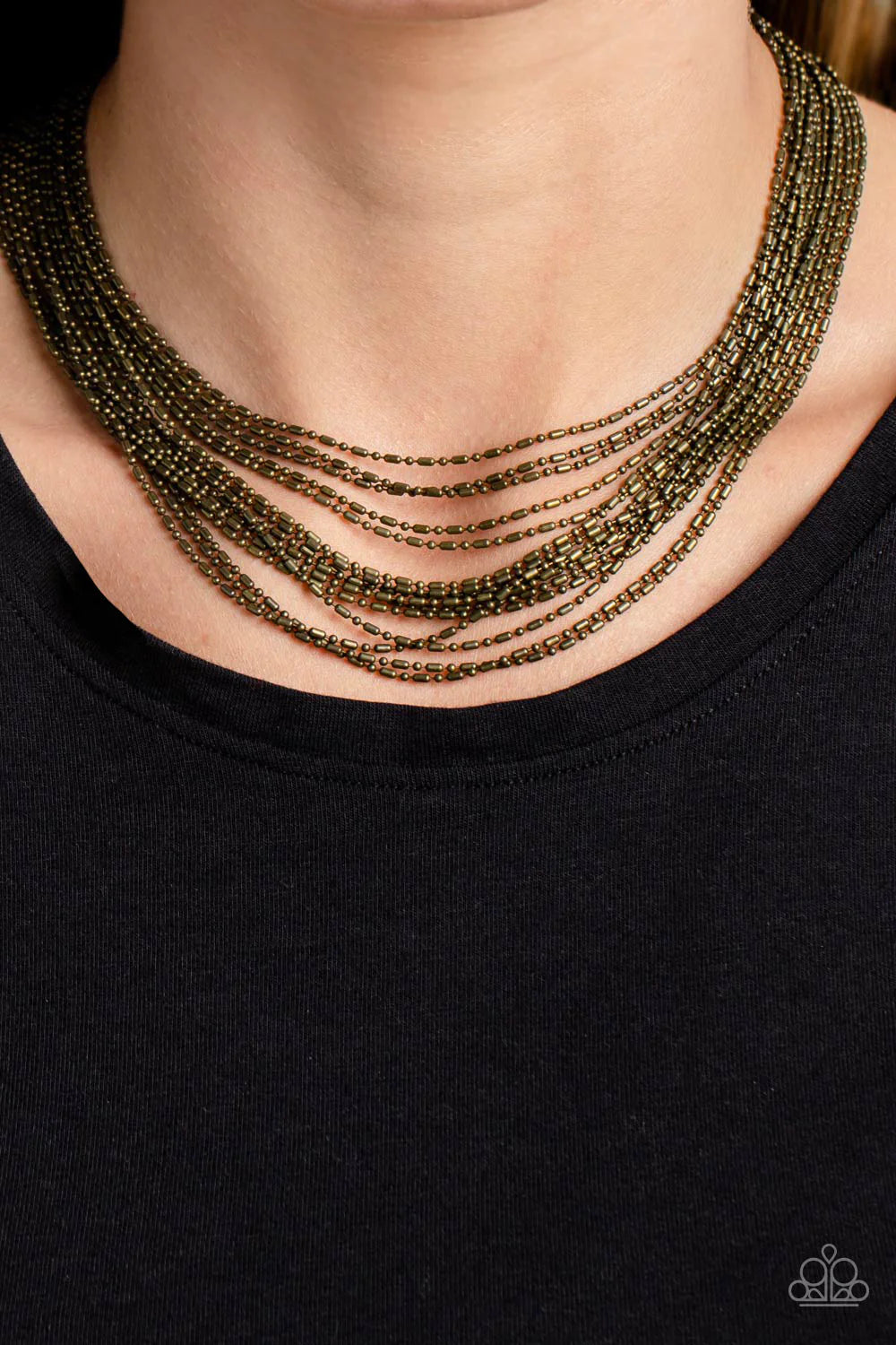 Paparazzi Accessories Cascading Chains - Brass Suspended from two brass, horizontal bars, a shimmery cascade of brass ball-and-bar chains layer around the neck for an industrial statement. Features an adjustable clasp closure. Sold as one individual neckl