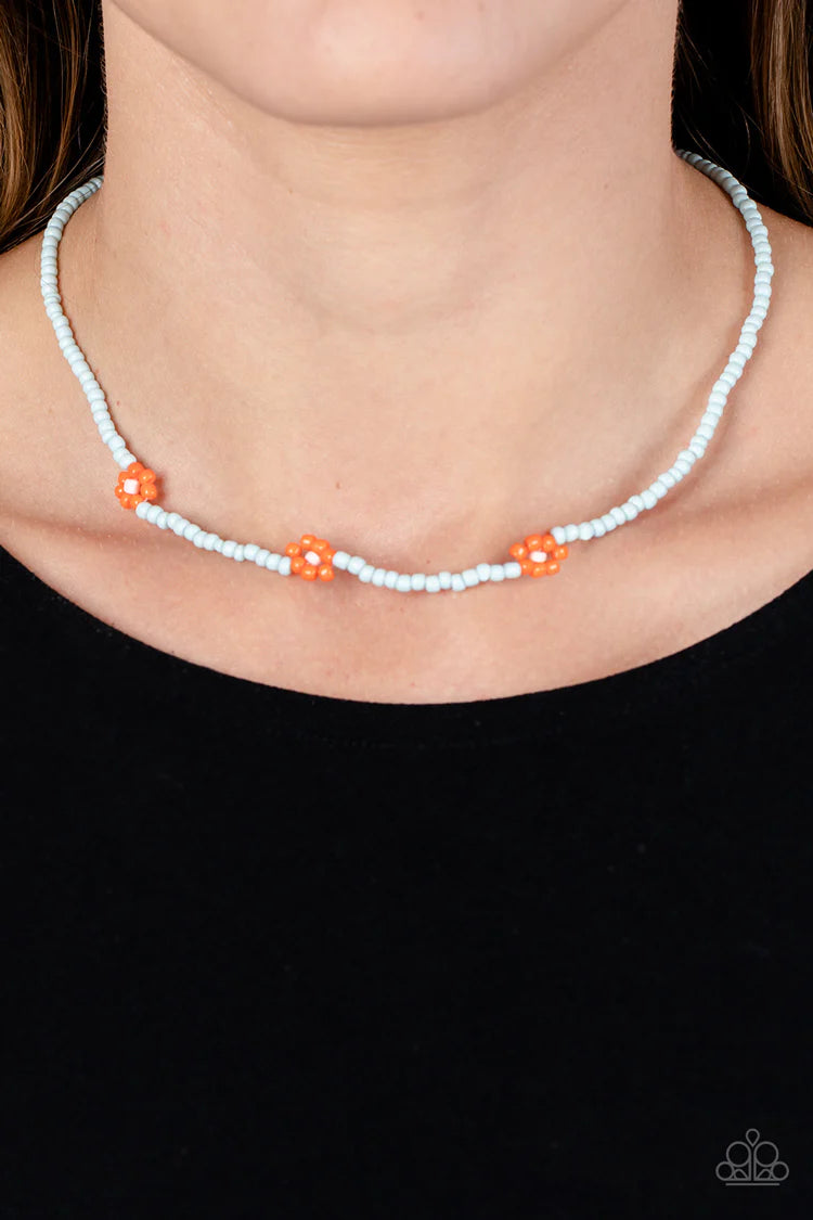 Paparazzi Accessories Bewitching Beading - Orange Strung along the entirety of an invisible wire, light blue seed beads coalesce around the collar. The row of blue seed beads are haphazardly interrupted by blooming orange seed bead flowers, with baby pink
