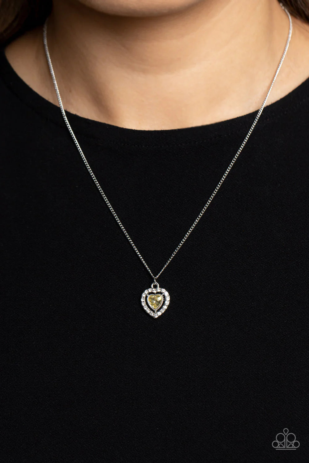 Paparazzi Accessories Day of Love - Yellow Dainty, glittery white rhinestones encircle a pronged, yellow heart shaped gem, creating a flirty and dainty pendant below the collar. Features an adjustable clasp closure. Sold as one individual necklace. Includ