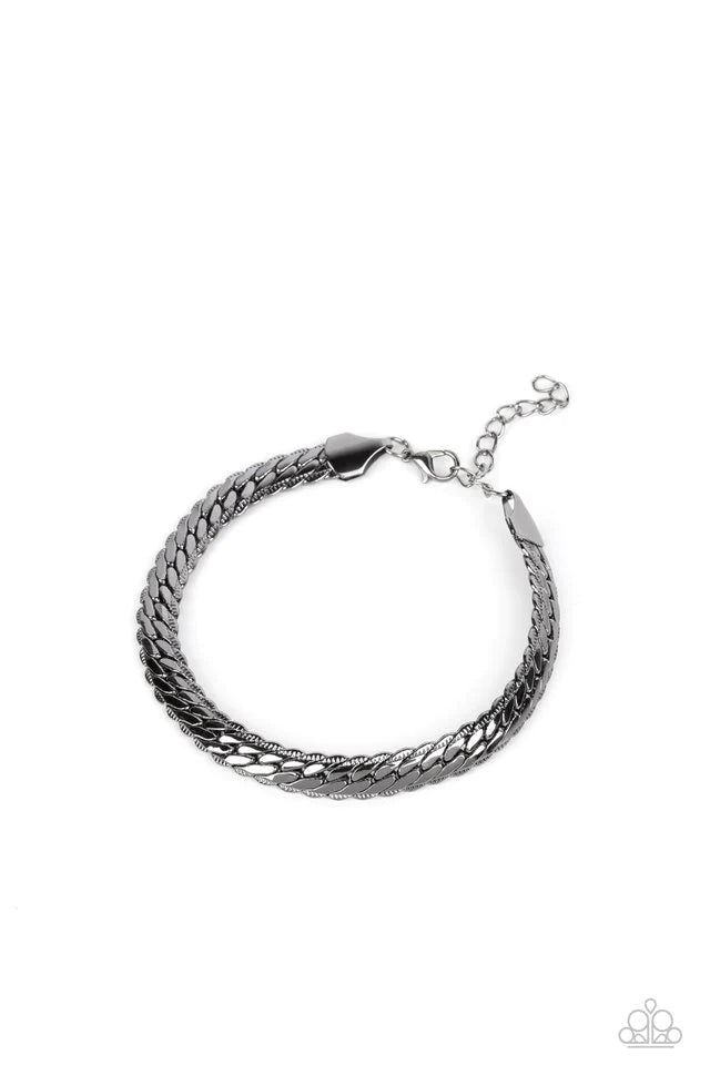 Paparazzi Accessories Cargo Couture - Black Brushed in a high-sheen finish, a thick, gunmetal chain wraps around the wrist for an industrial look. Featured within the design, the chain seems to tightly stack on top of itself, emitting light from every ang
