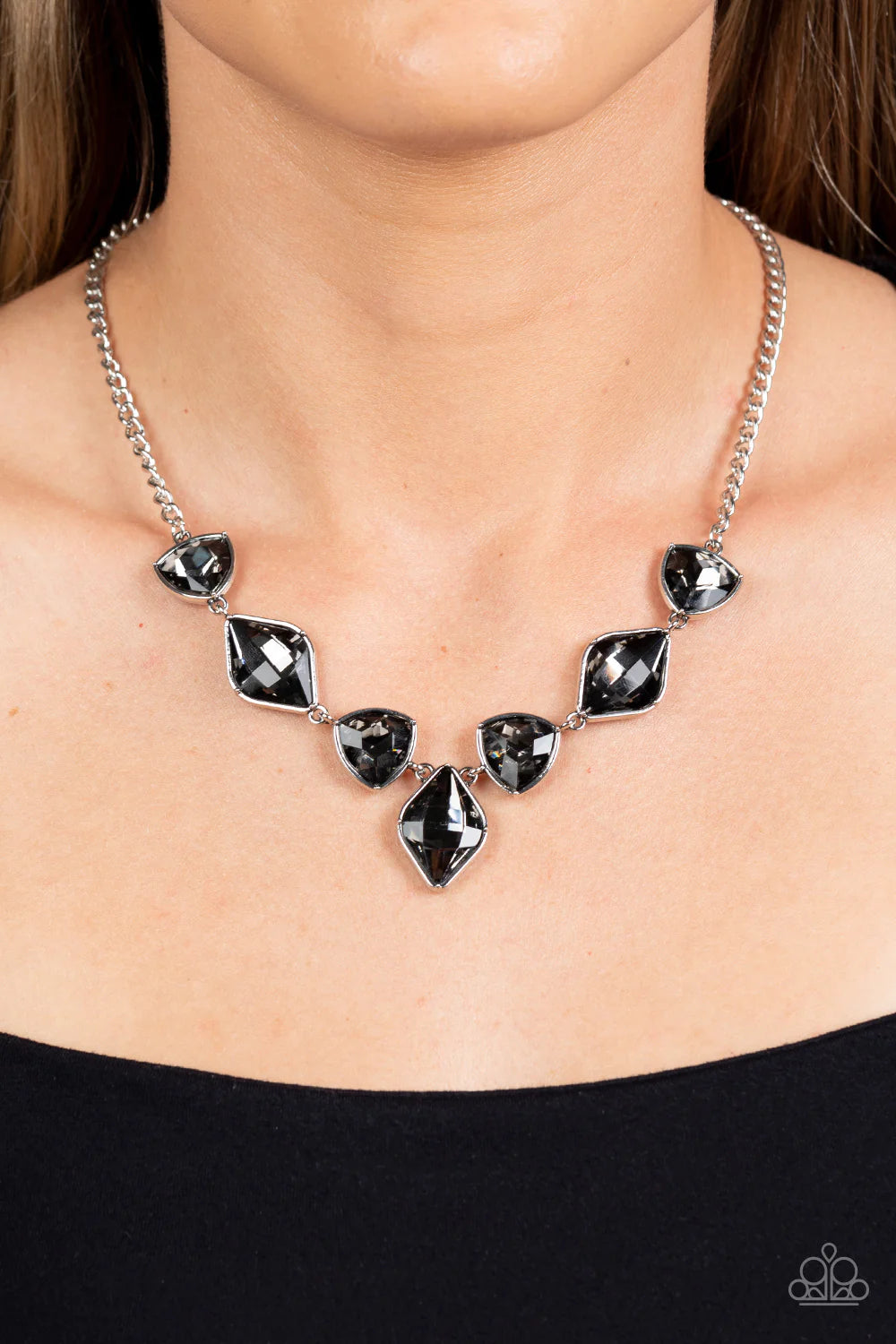 Paparazzi Accessories Glittering Geometric - Silver Set in silver frames, glittering geometric shapes with a smoky shimmer delicately coalesce around the collar for a statement piece. Features an adjustable clasp closure. Sold as one individual necklace.