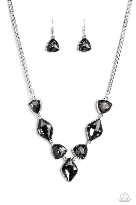 Paparazzi Accessories Glittering Geometric - Silver Set in silver frames, glittering geometric shapes with a smoky shimmer delicately coalesce around the collar for a statement piece. Features an adjustable clasp closure. Sold as one individual necklace.