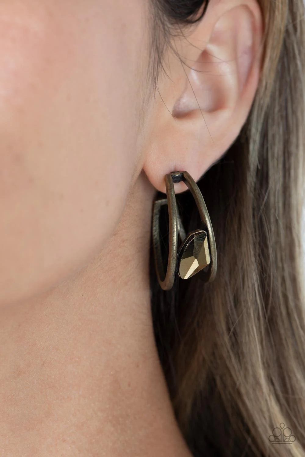Paparazzi Accessories Unrefined Reverie - Brass Two thick, brass crescent frames curve into bold double hoops that curl behind the ear in a dramatic display. An asymmetrical-cut piece of aurum juts out from the hoop, adding a dash of shimmer to the edgy d