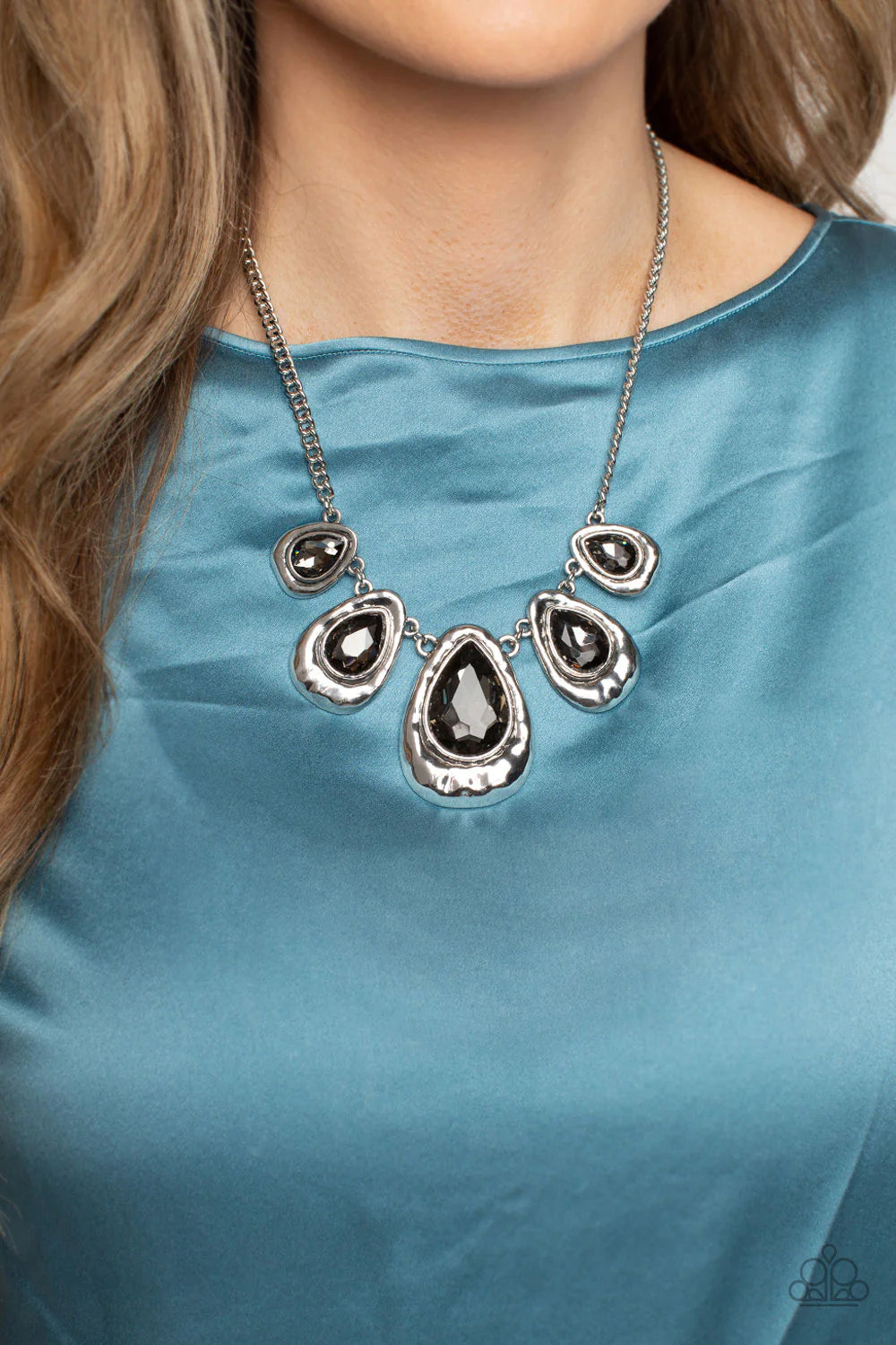 Paparazzi Accessories Formally Forged - Silver Delicately hammered in shimmer, a collection of shiny silver teardrops link below the collar for an edgy statement-making look. Set in each hammered frame, faceted, smoky teardrop gems add a dramatic pop of c
