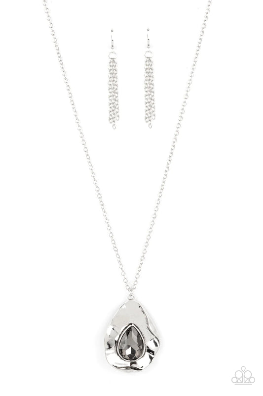 Paparazzi Accessories Surrealist Sparkle - Silver A warped silver frame gently folds around an oversized smoky teardrop gem center, resulting in a gritty yet glamorous pendant at the bottom of a lengthened silver chain. Features an adjustable clasp closur