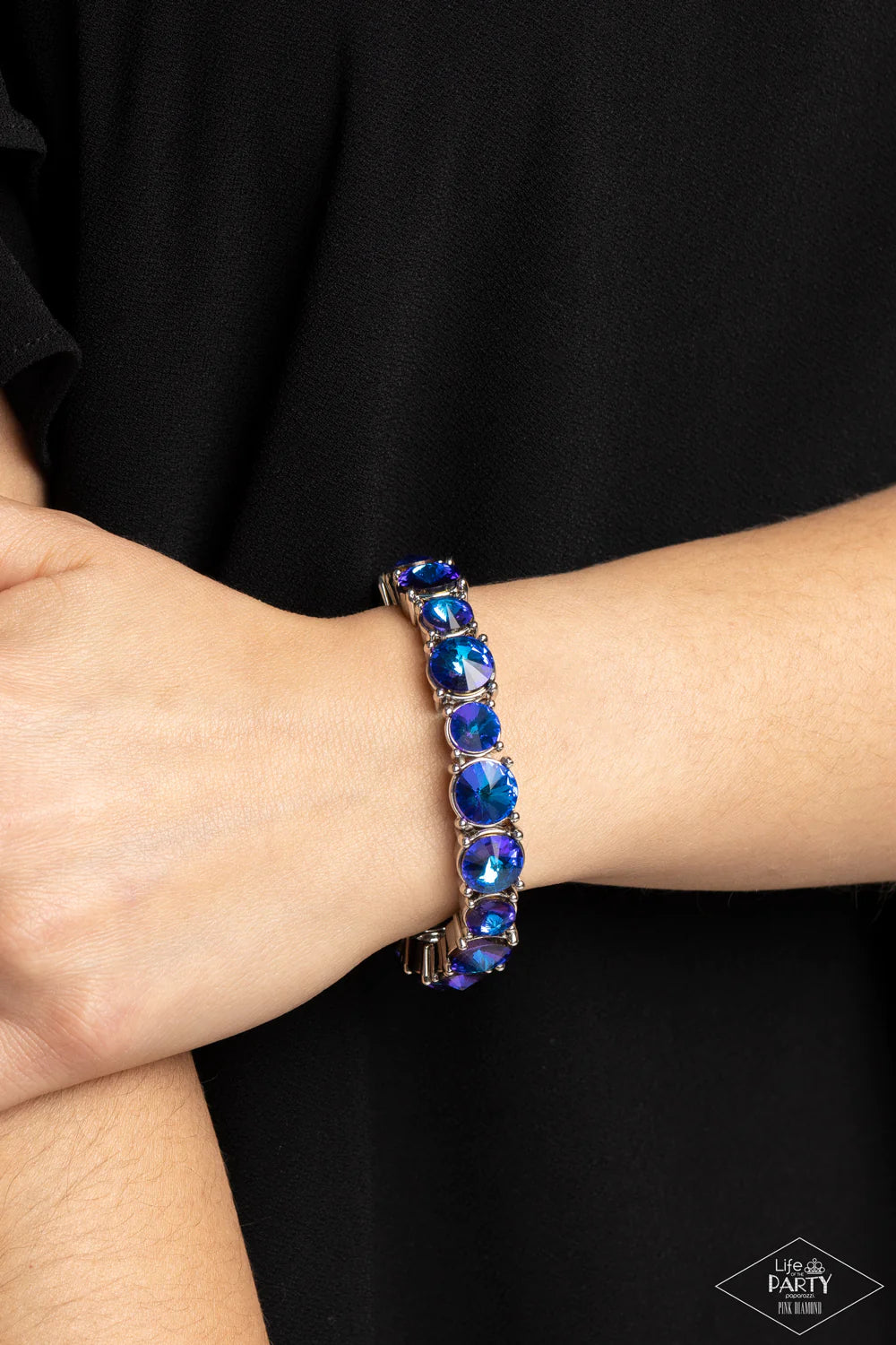 Paparazzi Accessories Born to Bedazzle - Blue An assortment of oversized blue oil spill rhinestones are pressed into silver frames and threaded along stretchy bands, creating a blinding sparkle around the wrist. Due to its prismatic palette, color may var