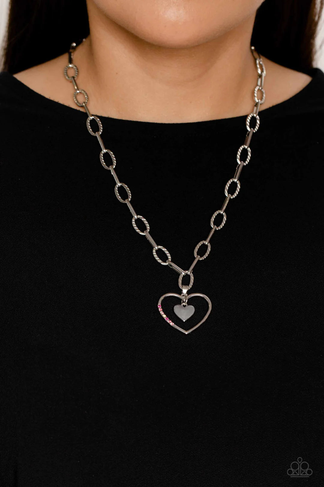 Paparazzi Accessories Refulgent Romance - Pink Textured ovals and elongated silver links lead the eye down to an oversized, airy, silver heart frame. Encrusted along one of the curves of the silver heart, dainty rhinestones in shades of pink, including fu