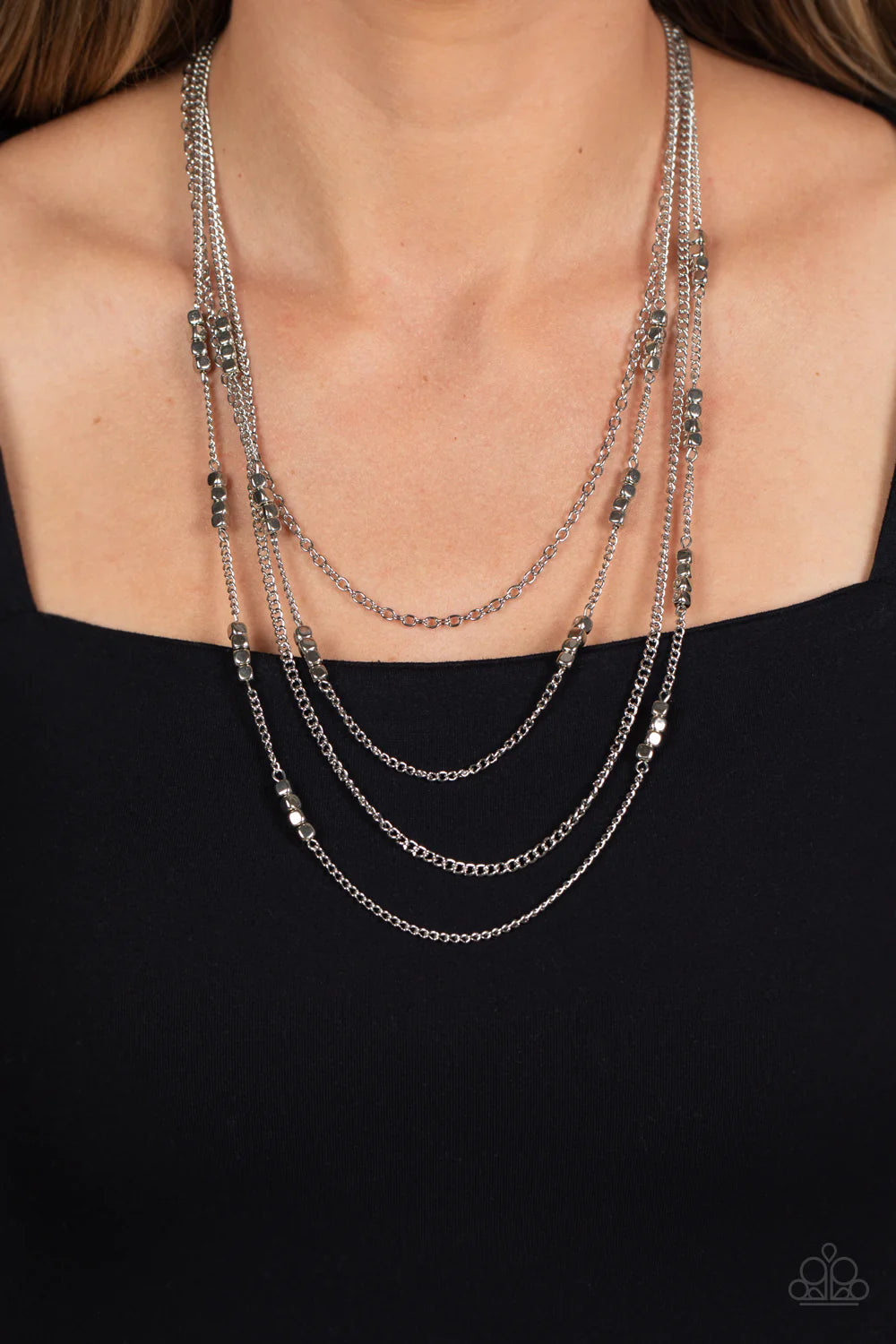 Paparazzi Accessories Metallic Monarch - Silver Glistening silver chains, sporadically infused with a quartet of silver beads link into fashionable layers below the neckline for a monochromatic medley. Features an adjustable clasp closure. Sold as one ind