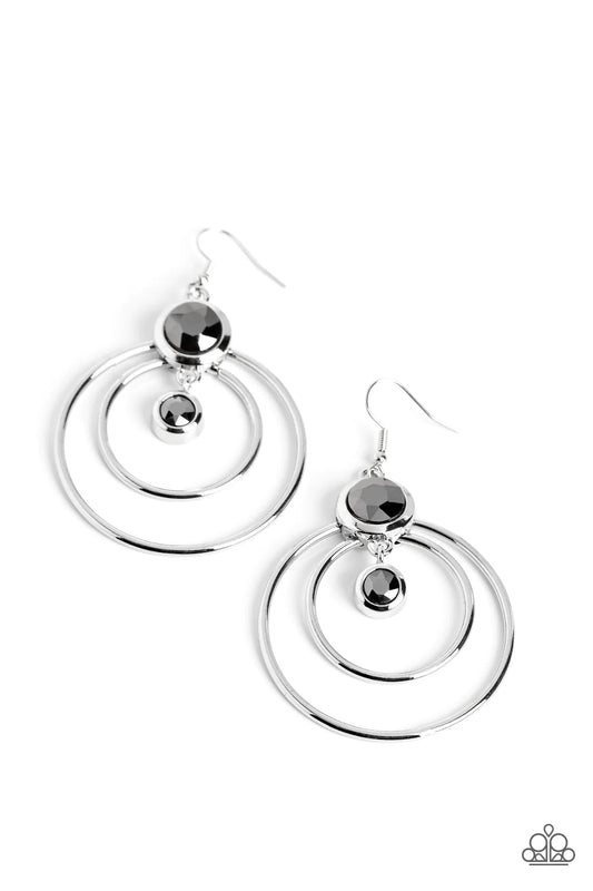 Paparazzi Accessories Dapperly Deluxe - Silver Two airy hoops anchor an oversized smoky hematite rhinestone set in a thick silver frame for some playful movement. Dangling below the oversized hematite rhinestone, a dainty rhinestone set in the same frame