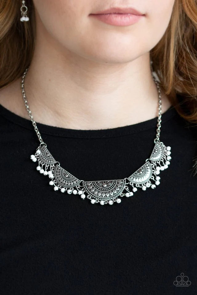 Paparazzi Accessories Boho Baby - White Embossed in tribal inspired patterns, silver half-moon frames link below the collar. Dainty white beads swing from the bottoms of the ornate frames, creating a flirtatious fringe. Features an adjustable clasp closur