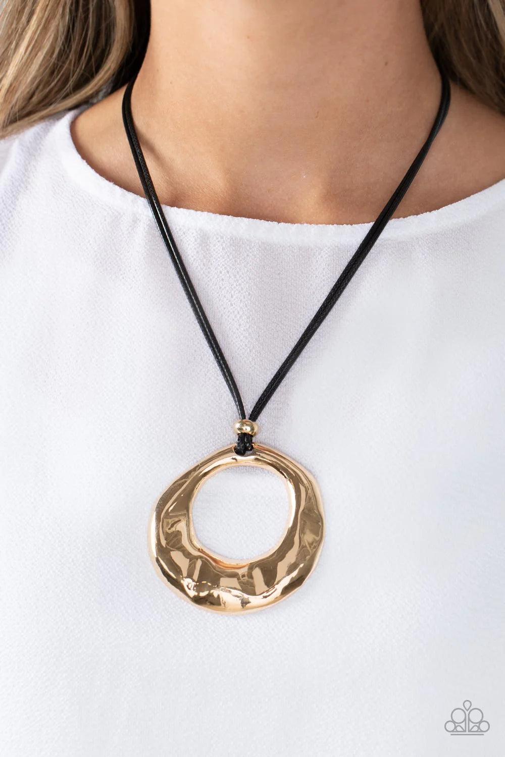 Paparazzi Accessories Tectonic Treasure - Gold An oversized, oblong, gold hoop rippling with hammered textures swings from the bottom of a collection of black cording. A single gold bead glides down the bottom of the cording for a dramatic industrial look