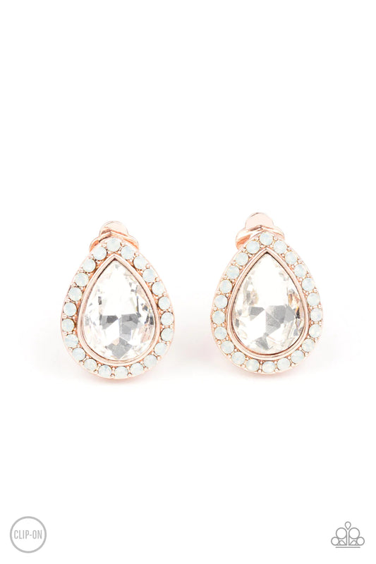 Paparazzi Accessories Cosmic Castles - Rose Gold *Clip-On A faceted white teardrop gem is pressed into a rose gold frame bordered with opalescent white rhinestones for a glamorous finish. Earring attaches to a standard clip-on fitting. Sold as one pair of