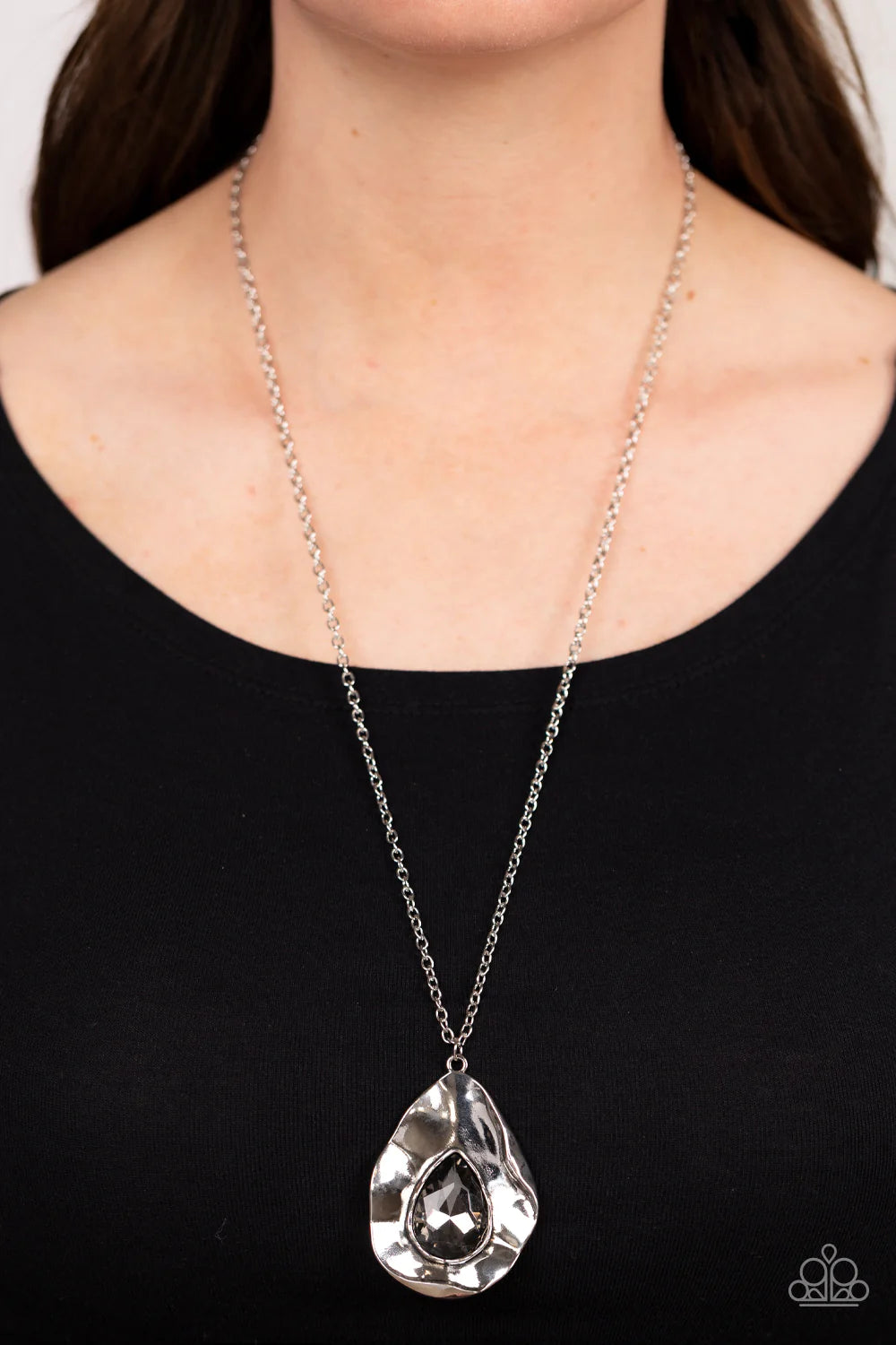 Paparazzi Accessories Surrealist Sparkle - Silver A warped silver frame gently folds around an oversized smoky teardrop gem center, resulting in a gritty yet glamorous pendant at the bottom of a lengthened silver chain. Features an adjustable clasp closur
