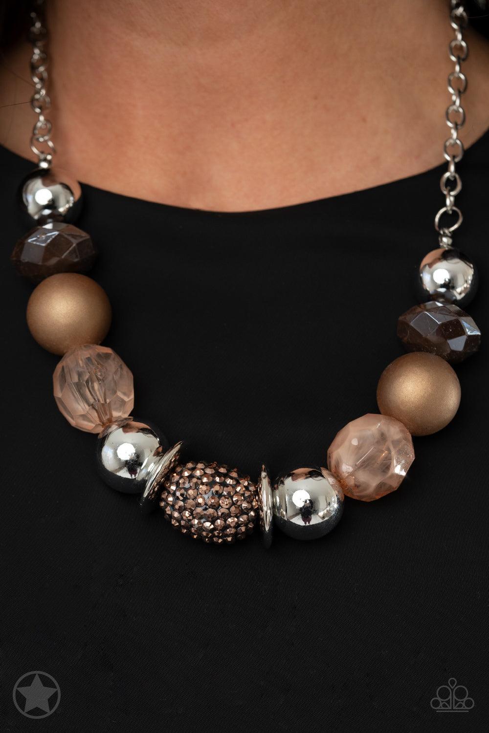 Paparazzi Accessories A Warm Welcome - Brown Warm beads in shades of brown and copper with reflective faceted edges and varying glazed finishes are offset by two shiny silver beads. An oblong bead studded with copper-toned rhinestones adds a dramatic acce