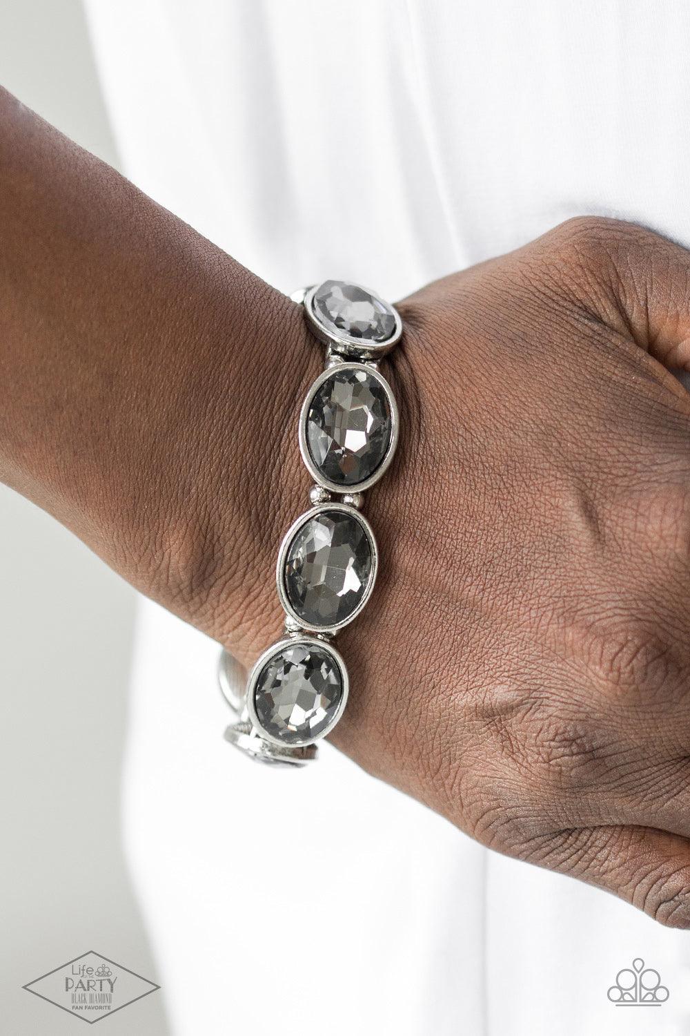 Paparazzi Accessories DIVA In Disguise - Silver Smoky gems are pressed into sleek silver frames. Infused with dainty silver beads, the glittery frames are threaded along stretchy elastic bands for a glamorous look around the wrist. Sold as one individual