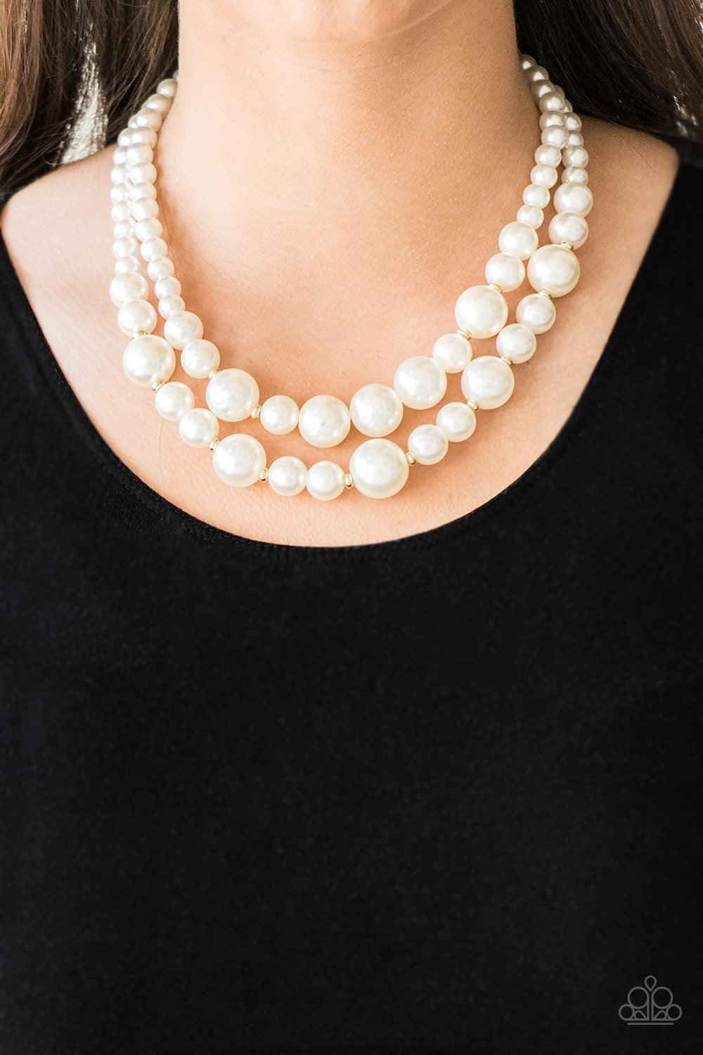 Paparazzi Accessories The More The Modest - Gold Infused with dainty gold accents, classic white pearls layer below the collar in a timeless fashion. Features an adjustable clasp closure. Sold as one individual necklace. Includes one pair of matching earr