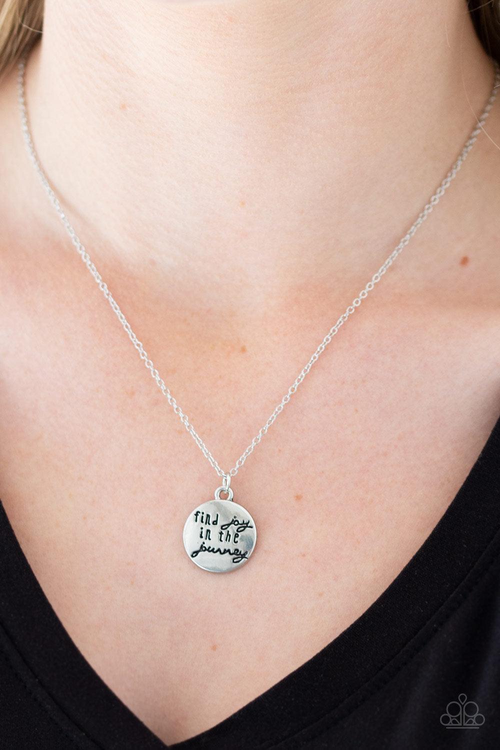 Paparazzi Accessories Find Joy - Silver Stamped in the inspirational phrase, "find joy in the journey," a round silver pendant swings below the collar for a seasonal look. Features an adjustable clasp closure. Sold as one individual necklace. Includes one