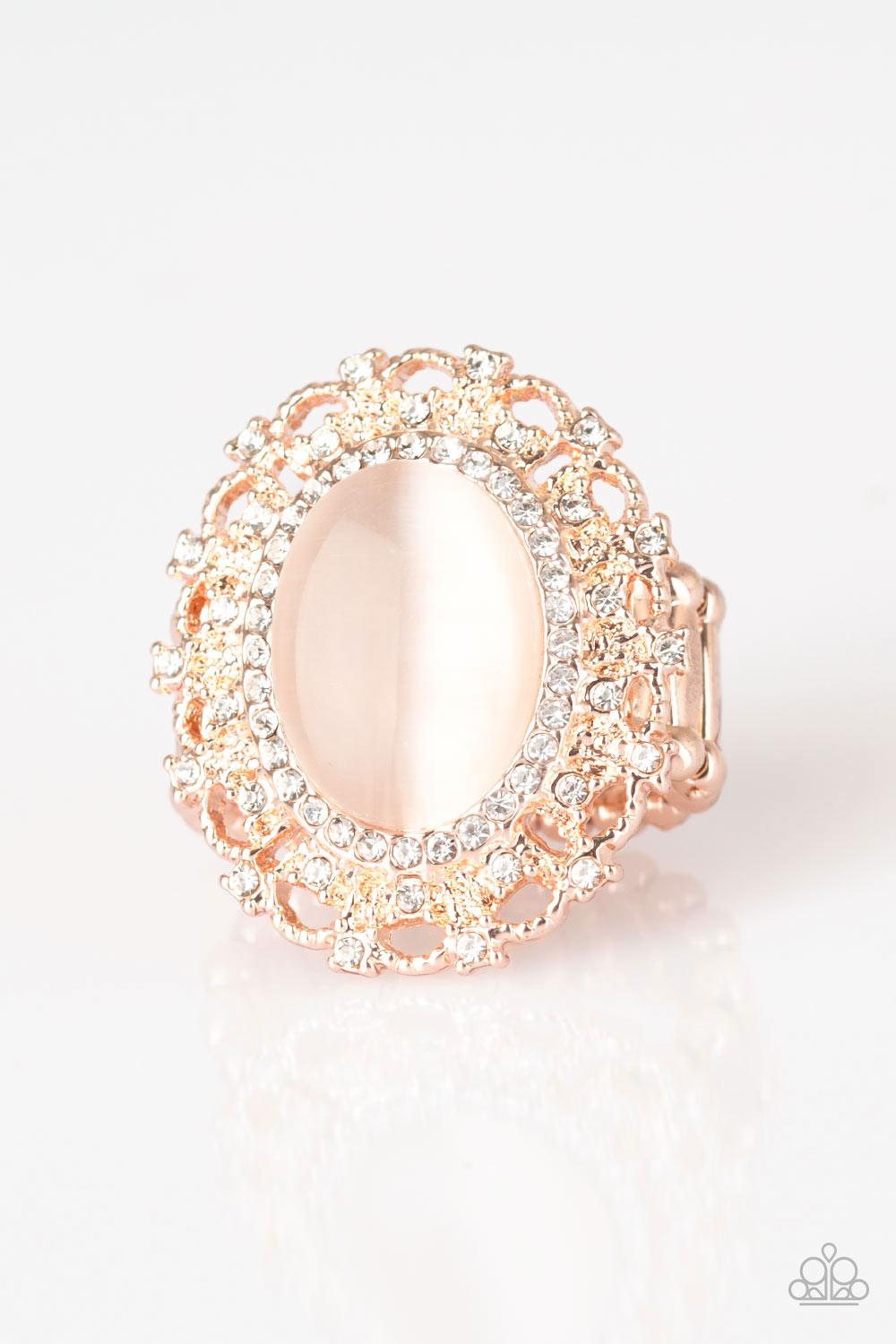 Paparazzi Accessories BAROQUE The Spell - Rose Gold Encrusted in dainty white rhinestones, a frilly rose gold frame spins around a glowing moonstone center for a regal look. Features a stretchy band for a flexible fit. Sold as one individual ring. Jewelry