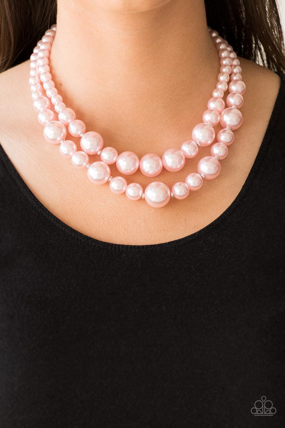 Paparazzi Accessories The More The Modest - Pink Infused with dainty silver accents, classic pink pearls layer below the collar in a timeless fashion. Features an adjustable clasp closure. Sold as one individual necklace. Includes one pair of matching ear