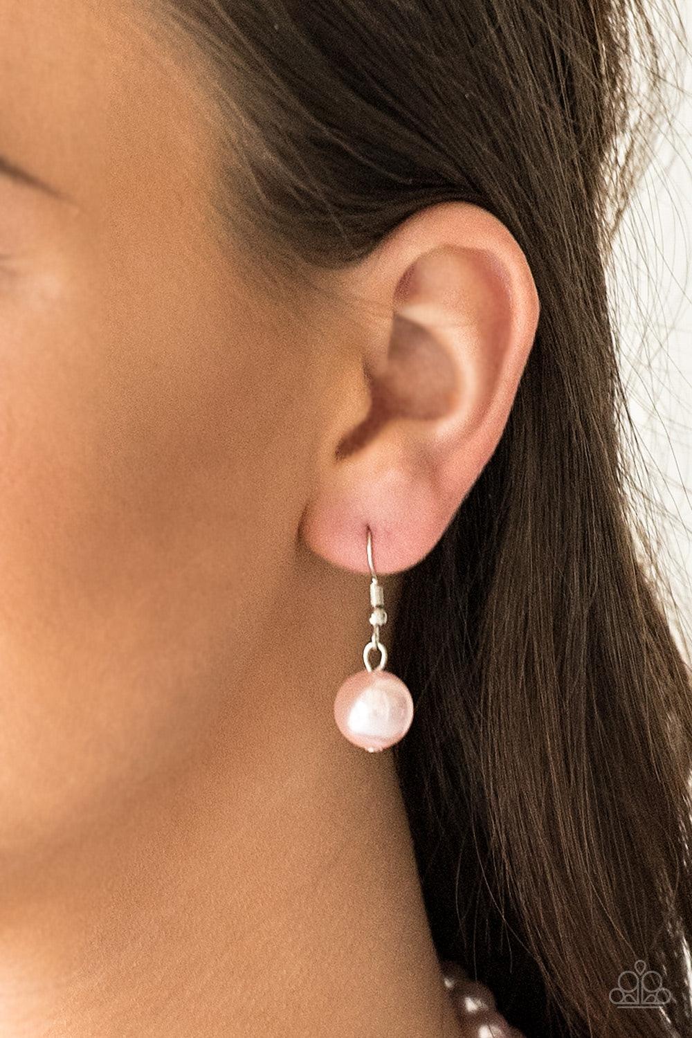Paparazzi Accessories The More The Modest - Pink Infused with dainty silver accents, classic pink pearls layer below the collar in a timeless fashion. Features an adjustable clasp closure. Sold as one individual necklace. Includes one pair of matching ear