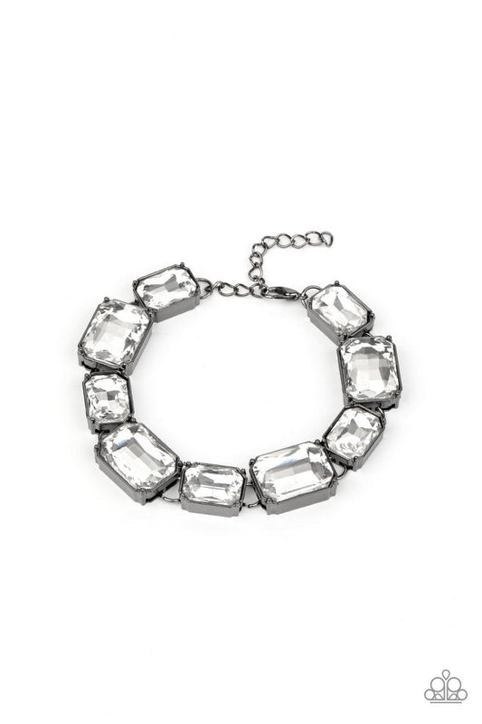 Paparazzi Accessories After Hours - Black Encased in sleek gunmetal fittings, a regal chain of small and large white emerald style gems alternate along the wrist for a timeless finish. Features an adjustable clasp closure. Sold as one individual bracelet.