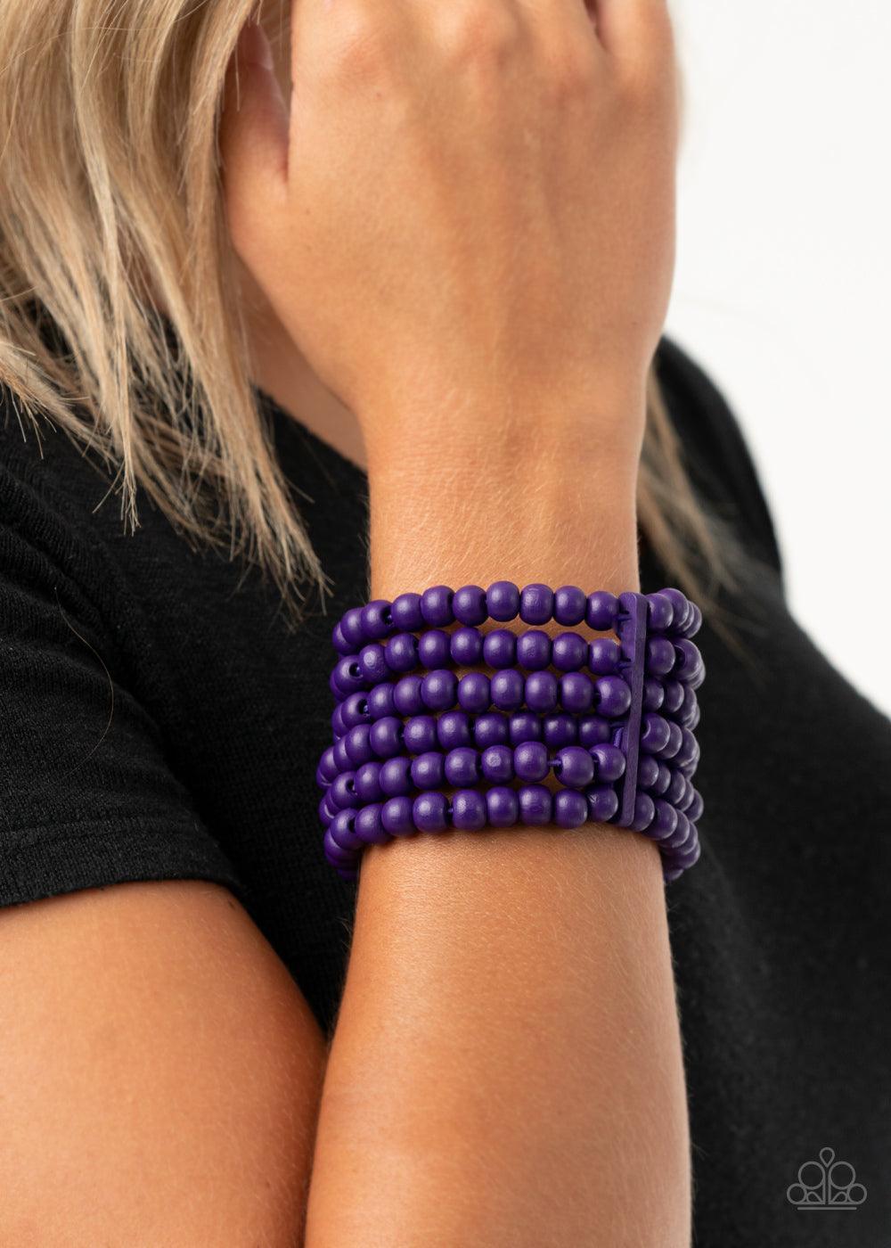 Paparazzi Accessories Diving in Maldives - Purple Held in place with rectangular wooden fittings, a collection of vivacious purple wooden beads are threaded along stretchy bands around the wrist, creating colorful layers. Sold as one individual bracelet.