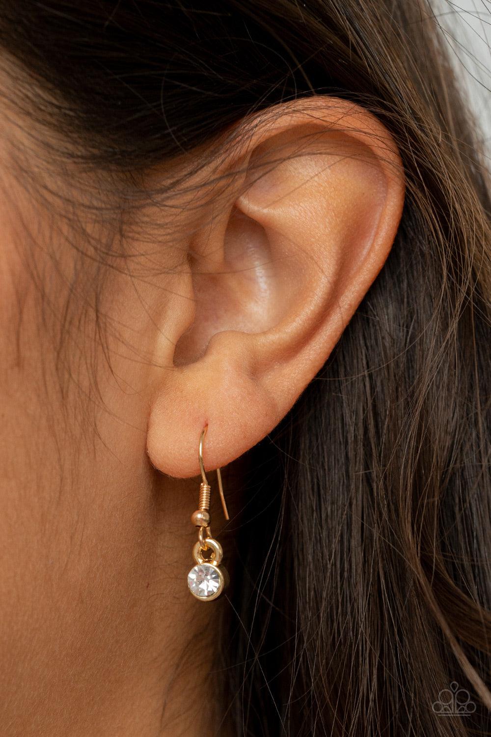 Paparazzi Accessories Curvy Couture - Gold Gradually increasing in size, two white rhinestone encrusted hoops link with a smooth gold hoop down the chest. The airy stacked pendant slides along a black leather cord for an elegantly edgy finish. Features an