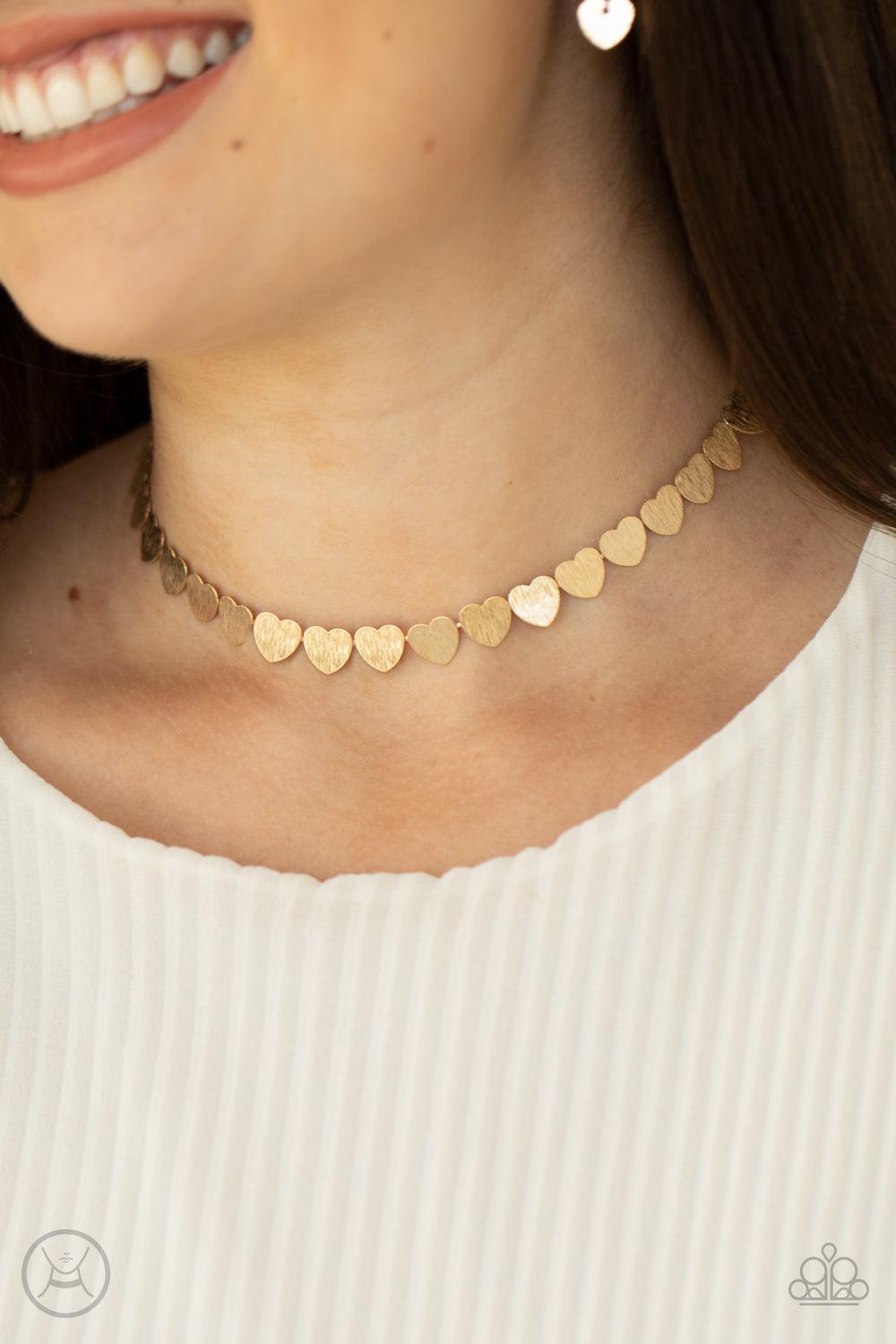 Paparazzi Accessories Playing HEART To Get - Gold Featuring a shimmery scratch finish, a dainty collection of shiny gold heart frames delicately connect around the neck for a flirtatious look. Feature an adjustable clasp closure. Sold as one individual ch