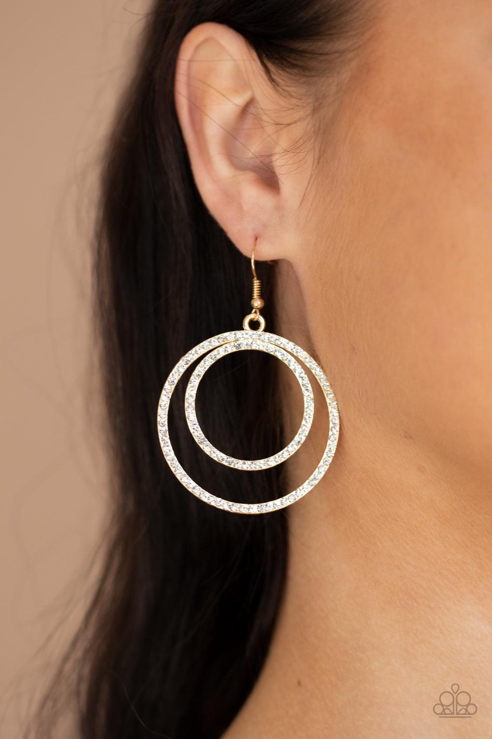 Paparazzi Accessories Radiating Refinement - Gold Encrusted in dainty white rhinestones, a pair of gold hoops delicately connect into a rippling frame for a glamorous finish. Earring attaches to a standard fishhook fitting. Sold as one pair of earrings. J
