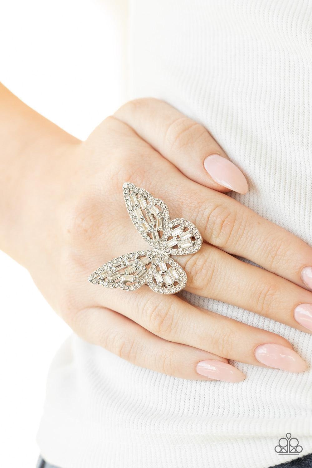 Paparazzi Accessories Flauntable Flutter - White Dainty white emerald style rhinestones are sprinkled across the wings of a silver butterfly that is encrusted in glassy white rhinestones for a dramatically dazzling finish. Features a stretchy band for a f